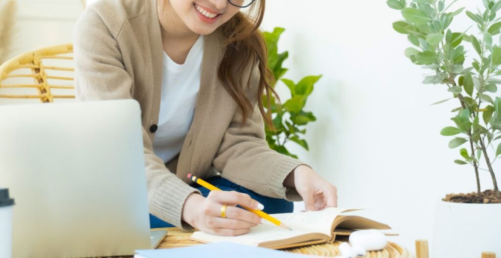 Mulher estudando e fazendo anotações, representando sucesso e autoconhecimento no empreendedorismo feminino.