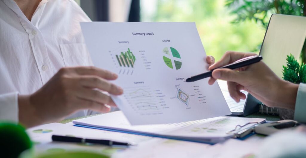 Relatório sobre sustentabilidade empresarial discutido por profissionais com gráficos de desempenho e ações climáticas.