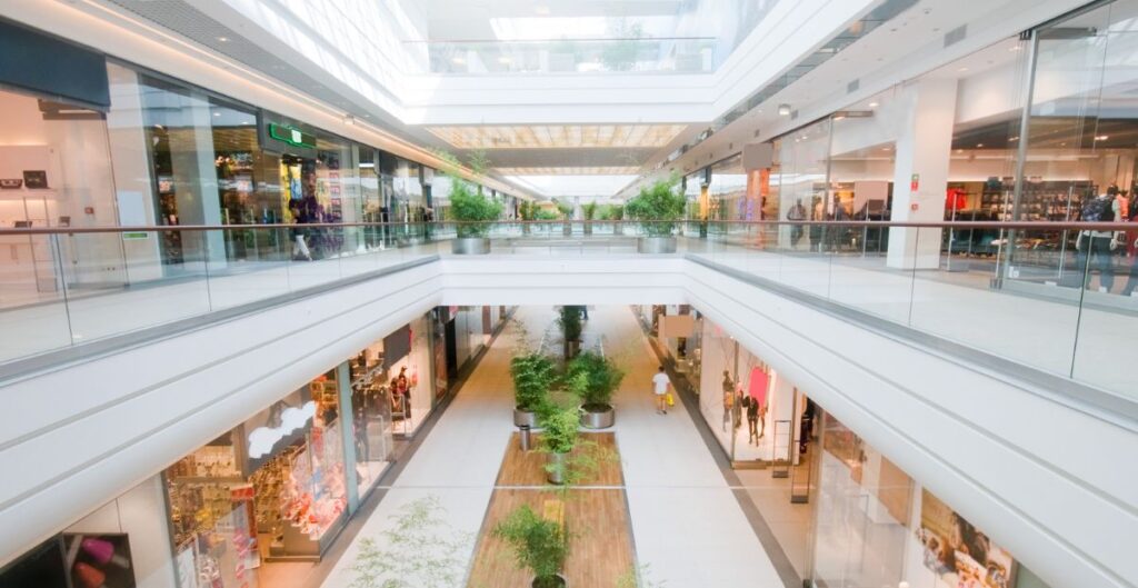 interior moderno de shopping center com lojas e plantas