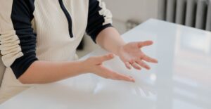 Mãos expressivas gesticulando durante uma conversa, representando linguagem corporal e comunicação não verbal.