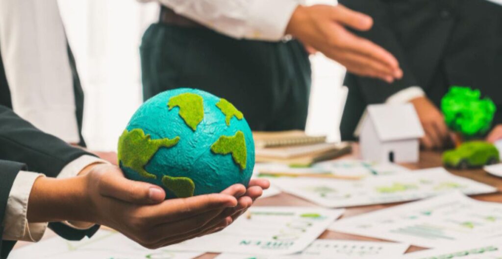 Pessoas segurando um globo terrestre em reunião sobre sustentabilidade e mudanças climáticas.